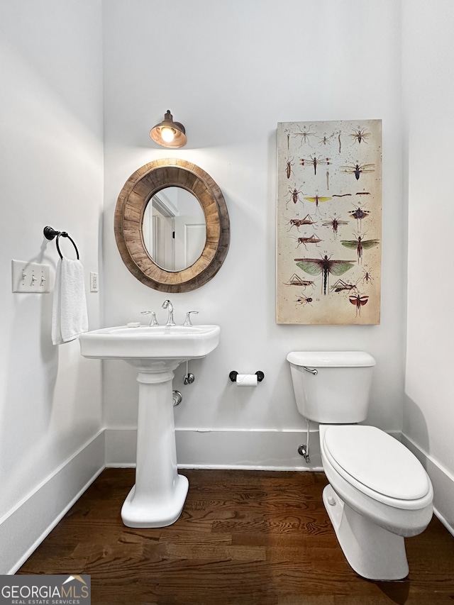 bathroom featuring toilet and wood-type flooring