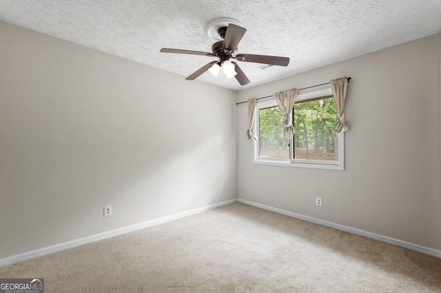 carpeted empty room featuring ceiling fan and a textured ceiling