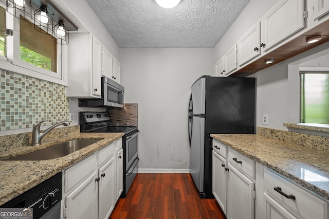 kitchen with appliances with stainless steel finishes, decorative backsplash, white cabinets, dark hardwood / wood-style flooring, and sink