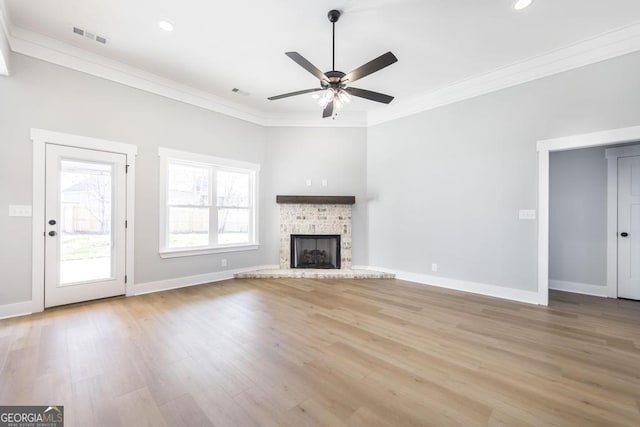 unfurnished living room featuring crown molding, ceiling fan, a brick fireplace, and light hardwood / wood-style flooring