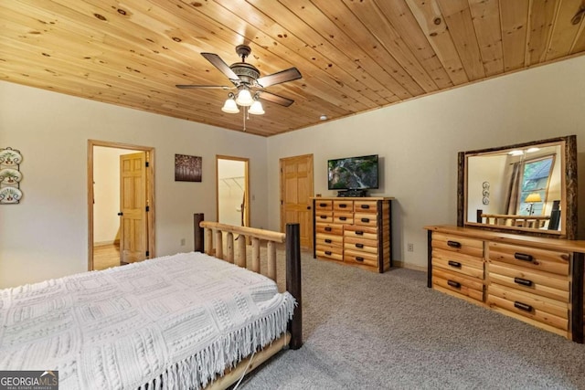 carpeted bedroom featuring a walk in closet, ceiling fan, and wood ceiling