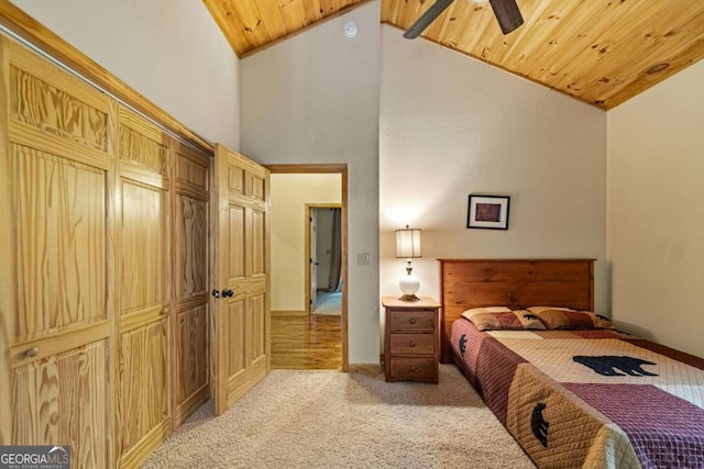 bedroom featuring light colored carpet, ceiling fan, high vaulted ceiling, wooden ceiling, and a closet