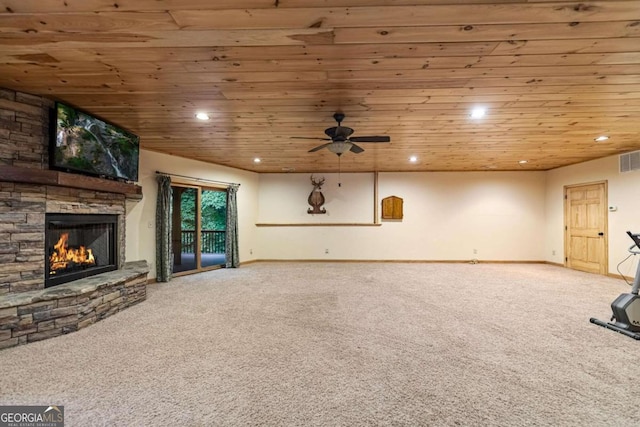 unfurnished living room featuring a stone fireplace, ceiling fan, carpet, and wood ceiling