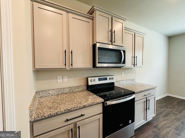 kitchen with stainless steel appliances, light stone counters, and dark hardwood / wood-style flooring