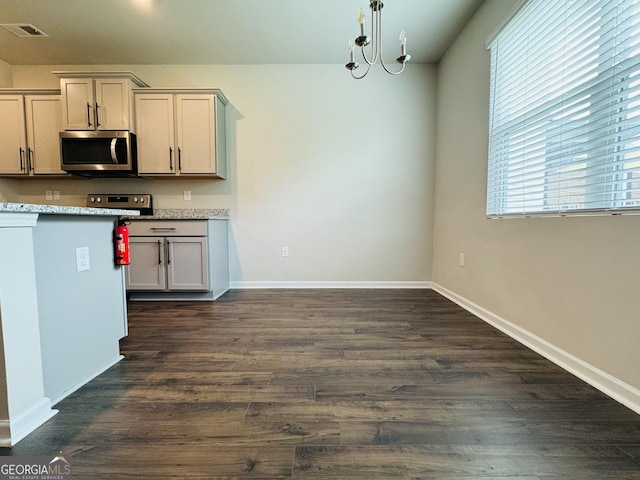 kitchen with dark wood-type flooring and a notable chandelier