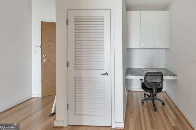 office area with built in desk and light wood-type flooring