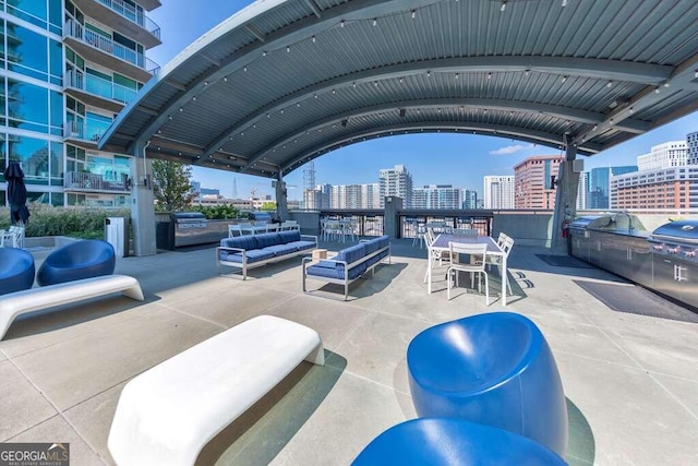 view of patio with grilling area, an outdoor living space, and a balcony