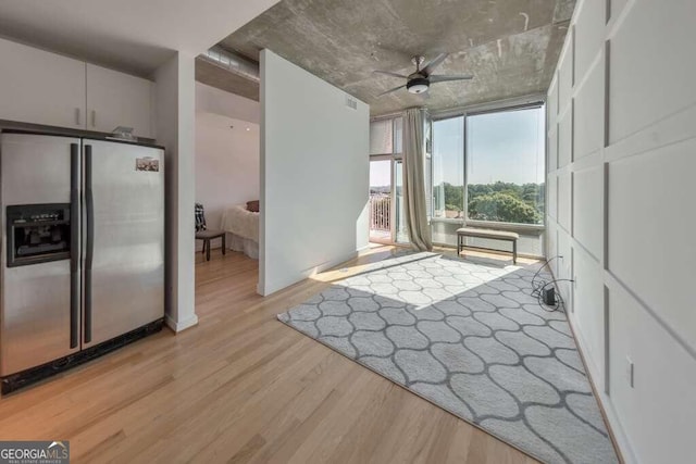 interior space with floor to ceiling windows, ceiling fan, and light hardwood / wood-style floors