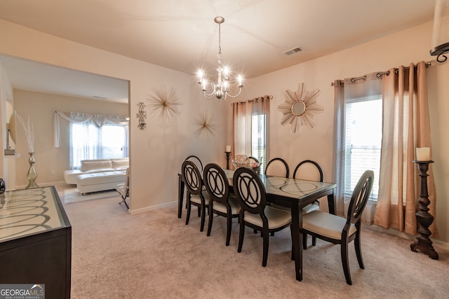 dining room featuring light carpet and a notable chandelier