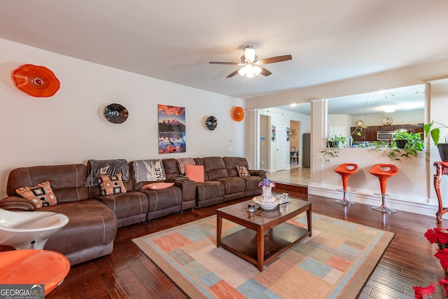 living room featuring ceiling fan and dark hardwood / wood-style floors