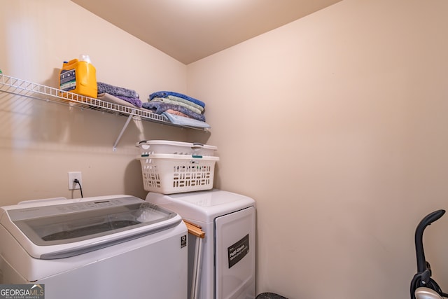 clothes washing area featuring washer and clothes dryer