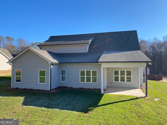 rear view of property featuring a yard and a patio