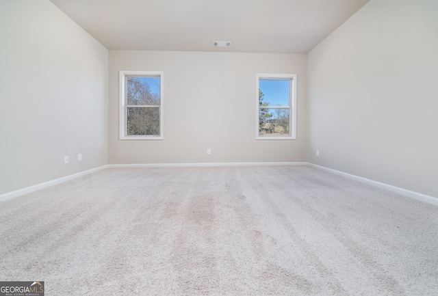 carpeted empty room featuring visible vents and baseboards