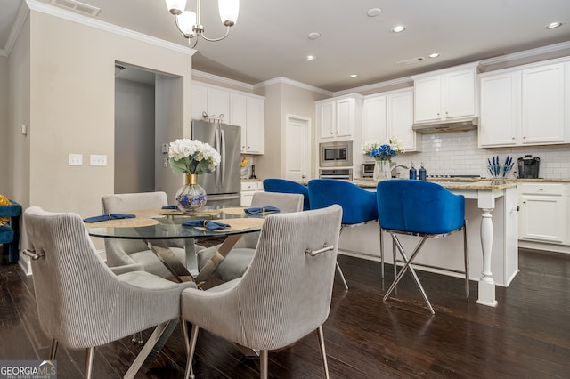 dining space with an inviting chandelier, ornamental molding, and dark hardwood / wood-style flooring