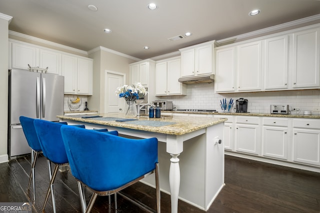 kitchen with stainless steel refrigerator, a kitchen island with sink, and dark hardwood / wood-style flooring