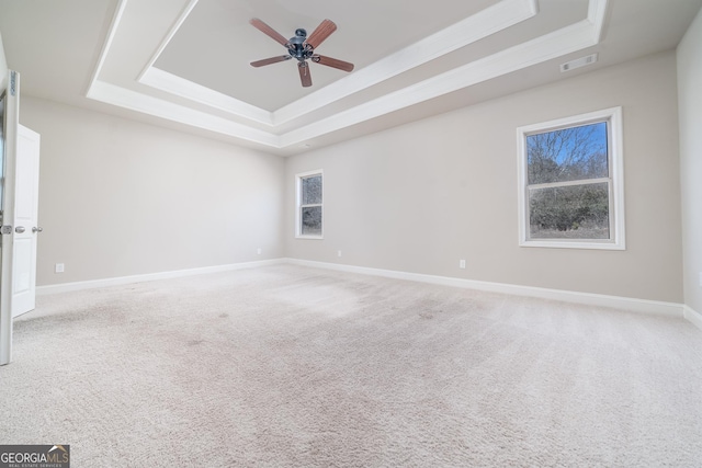 empty room with carpet, baseboards, visible vents, and a tray ceiling