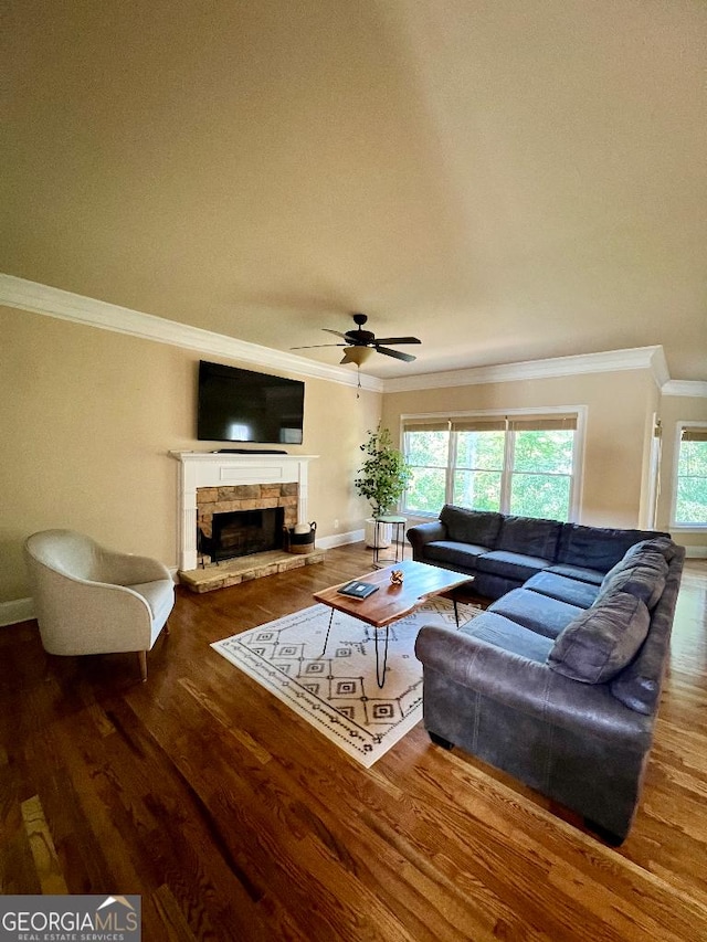 living room with a fireplace, wood-type flooring, ceiling fan, and crown molding