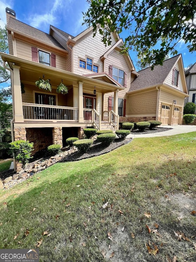 craftsman-style house with a front yard, a porch, and a garage