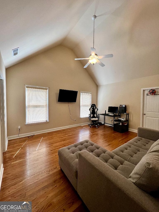 living room with wood-type flooring, vaulted ceiling, ceiling fan, and a healthy amount of sunlight