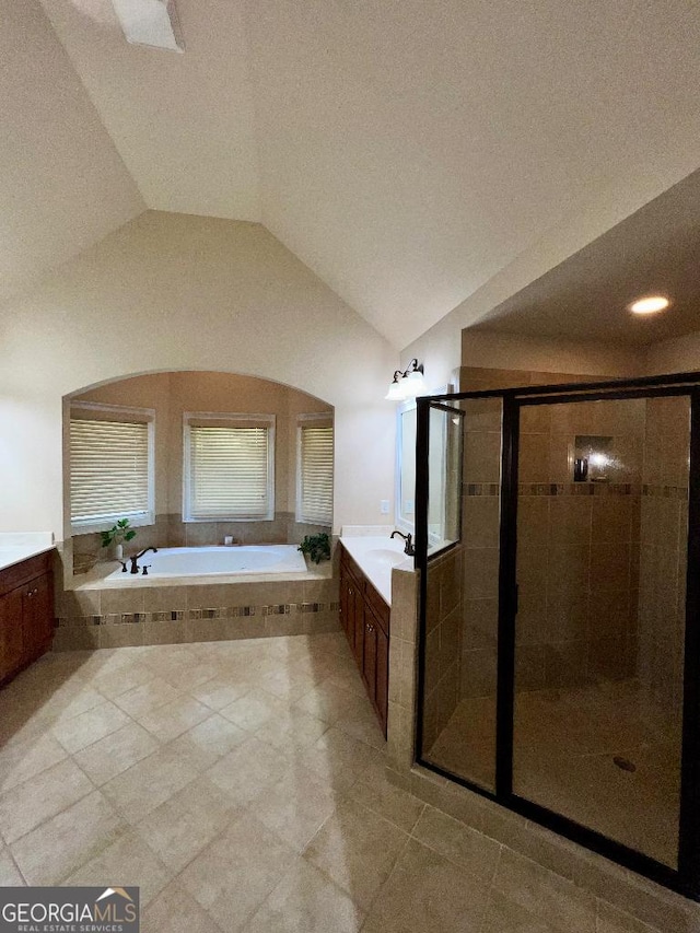 bathroom with tile patterned floors, vanity, vaulted ceiling, and shower with separate bathtub