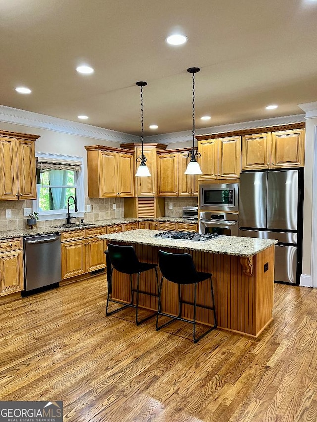 kitchen with appliances with stainless steel finishes, tasteful backsplash, a kitchen island, and sink