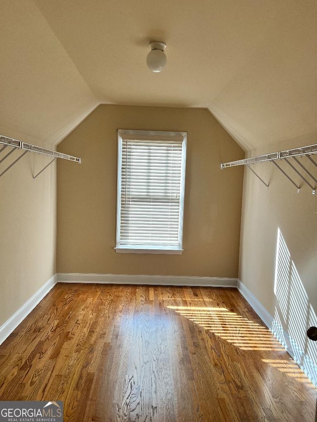 walk in closet with hardwood / wood-style floors and lofted ceiling