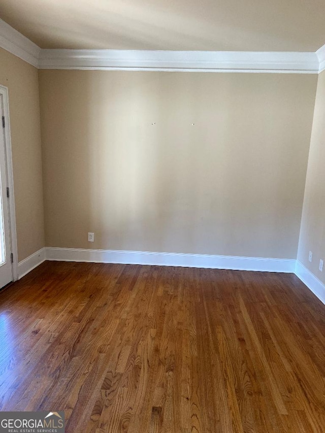 spare room featuring crown molding and wood-type flooring