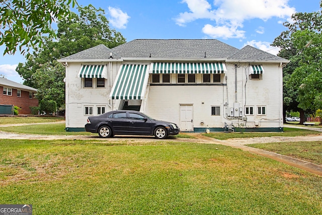 back of house with a lawn