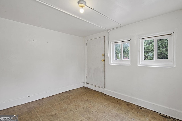 unfurnished room featuring baseboards and tile patterned floors