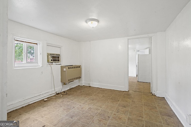 empty room with heating unit, baseboards, cooling unit, and tile patterned floors