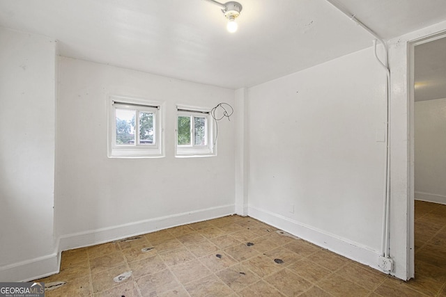 unfurnished room featuring light floors and baseboards