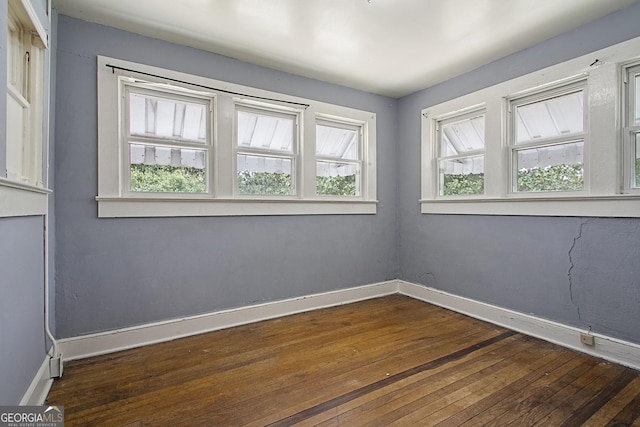 empty room with dark wood finished floors and baseboards