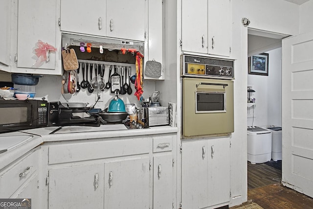 kitchen featuring light countertops, black microwave, oven, and white cabinets