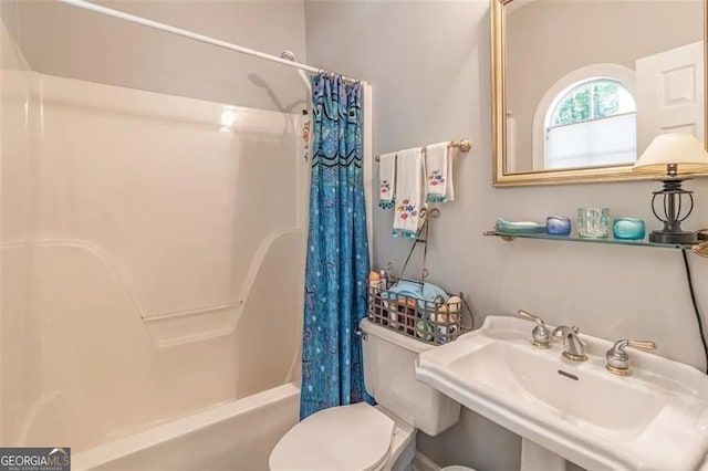 full bathroom with sink, shower / tub combo, and toilet