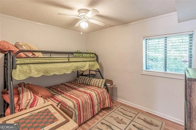 bedroom featuring ceiling fan, hardwood / wood-style flooring, and ornamental molding