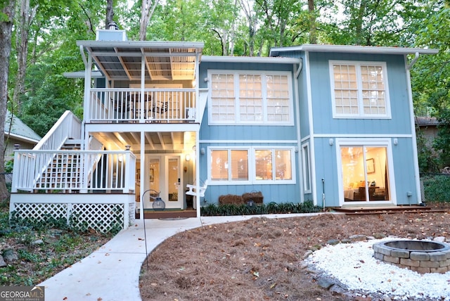 view of front facade with a fire pit, a balcony, and a patio area