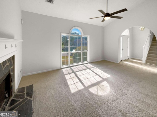 unfurnished living room featuring a fireplace, light carpet, ceiling fan, and lofted ceiling