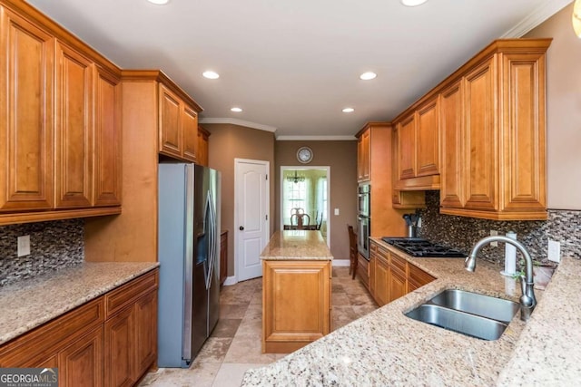 kitchen with appliances with stainless steel finishes, sink, light stone countertops, and decorative backsplash