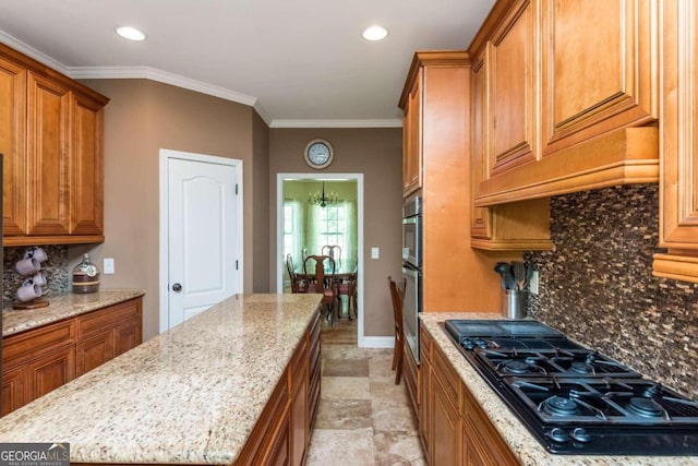 kitchen with crown molding, a center island, black gas cooktop, and light stone countertops