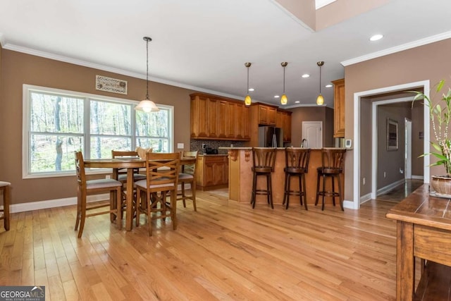 dining room featuring ornamental molding and light hardwood / wood-style floors