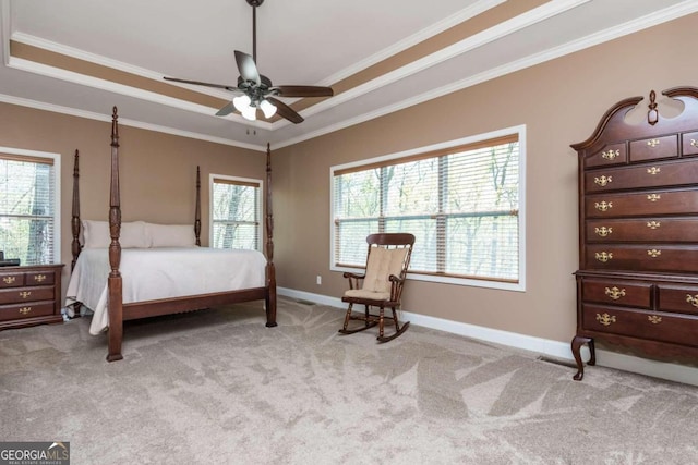 bedroom featuring crown molding, light carpet, a tray ceiling, and ceiling fan