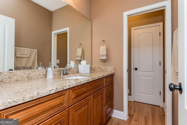 bathroom featuring vanity, toilet, and hardwood / wood-style flooring