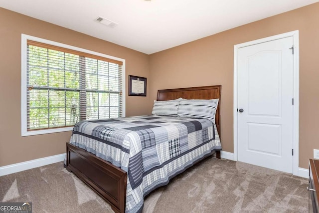 carpeted bedroom featuring multiple windows