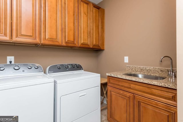 laundry area with independent washer and dryer, cabinets, and sink