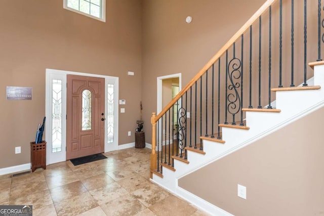 foyer entrance with a towering ceiling