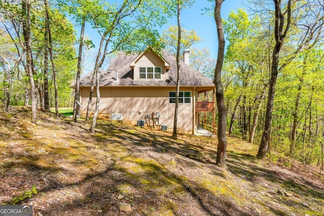 rear view of house featuring a wooden deck and cooling unit