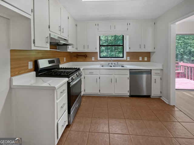 kitchen featuring white cabinets, stainless steel appliances, light tile patterned flooring, and sink