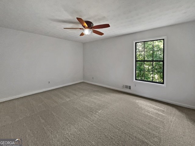 carpeted spare room featuring ceiling fan and a textured ceiling