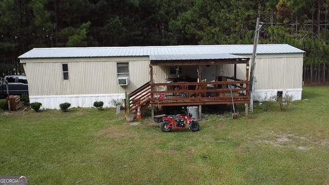 rear view of property with a lawn, cooling unit, and a deck