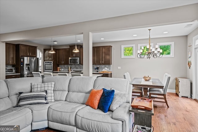 living room featuring a notable chandelier and light hardwood / wood-style floors